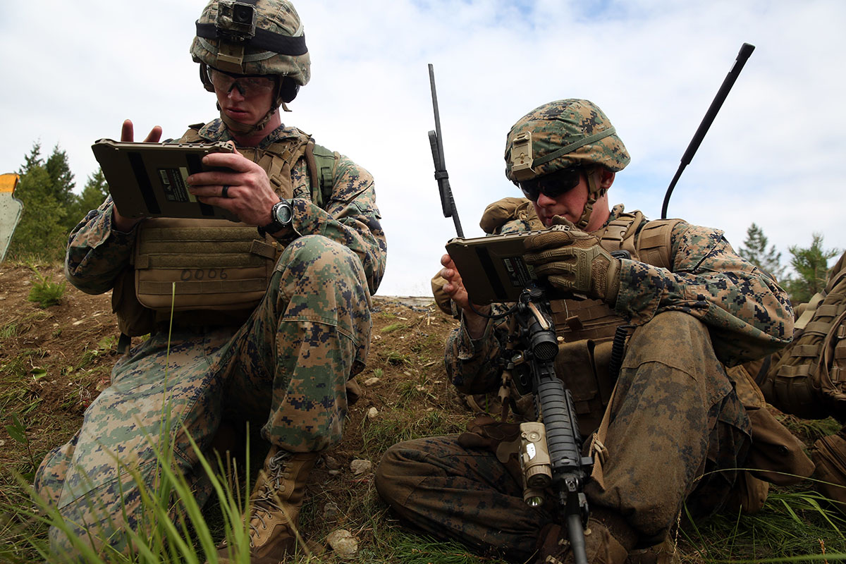 Marines in the field using rugged tablets during an operation