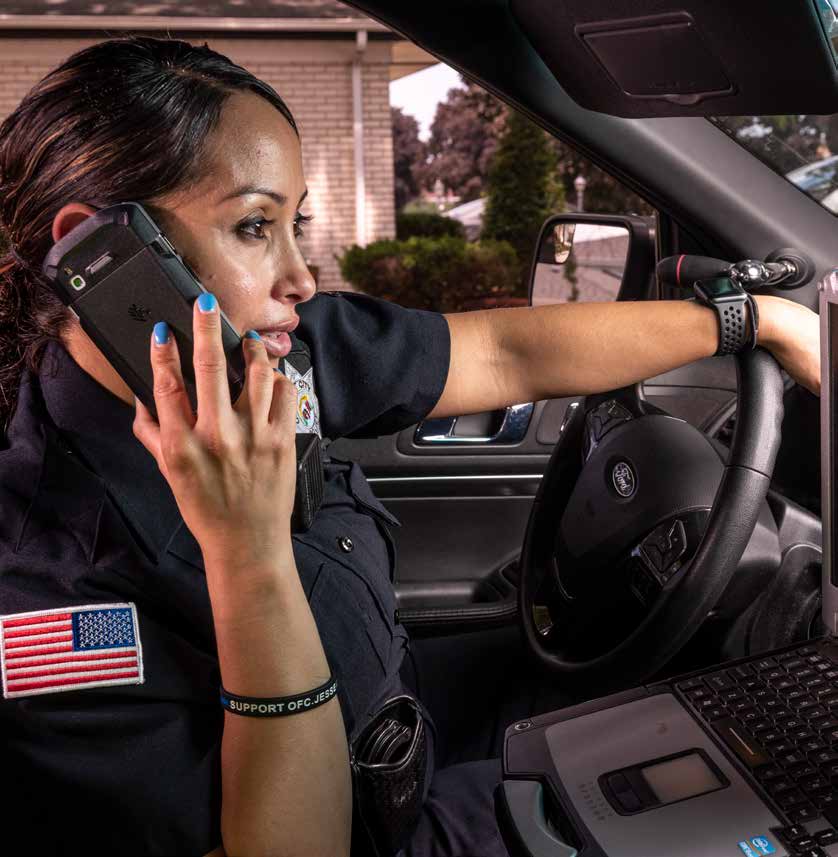 Police officer using a rugged device from a patrol car